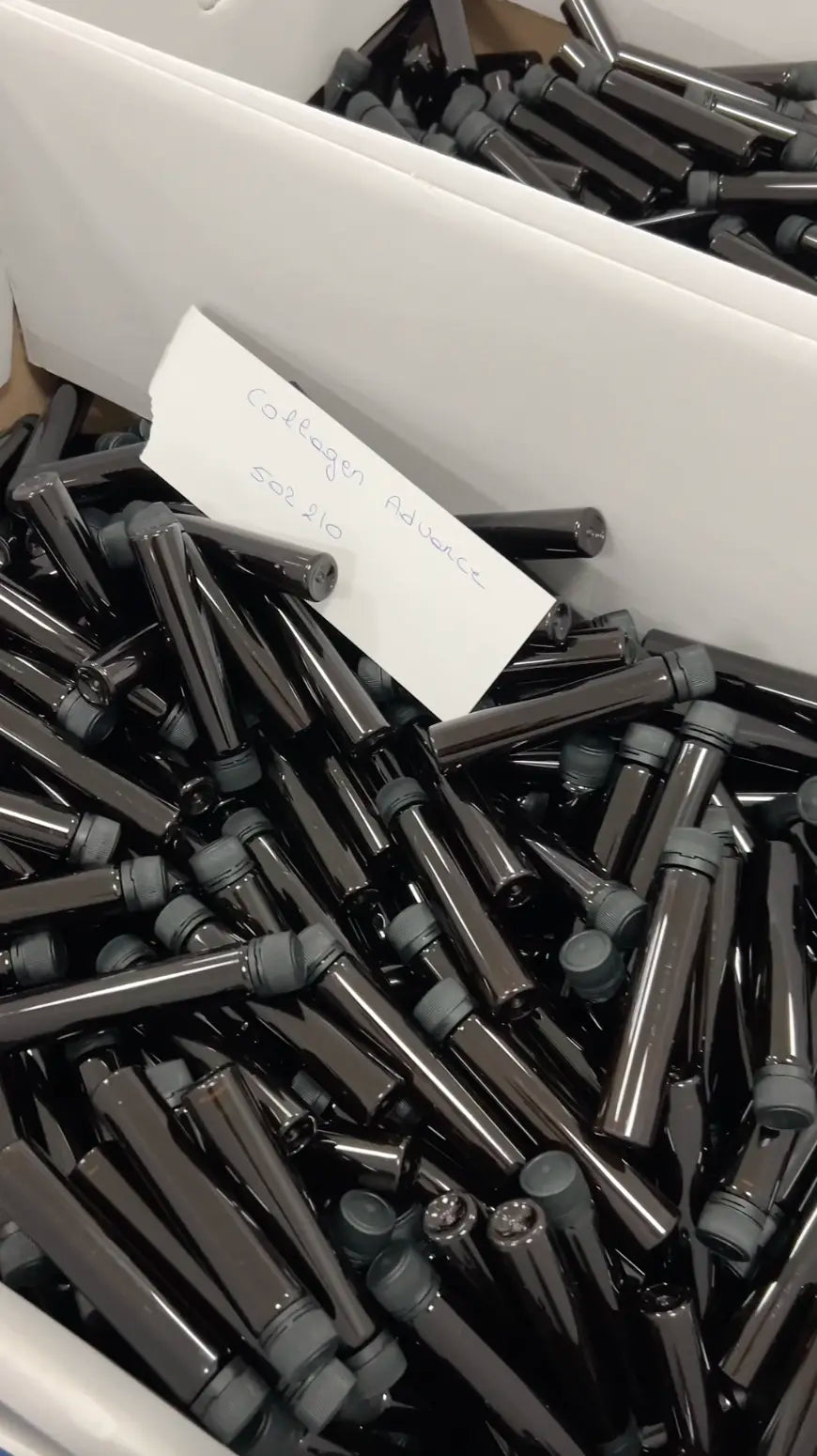 Bulkverpakking met donkere flacons van Collagen Advance+ vóór etikettering