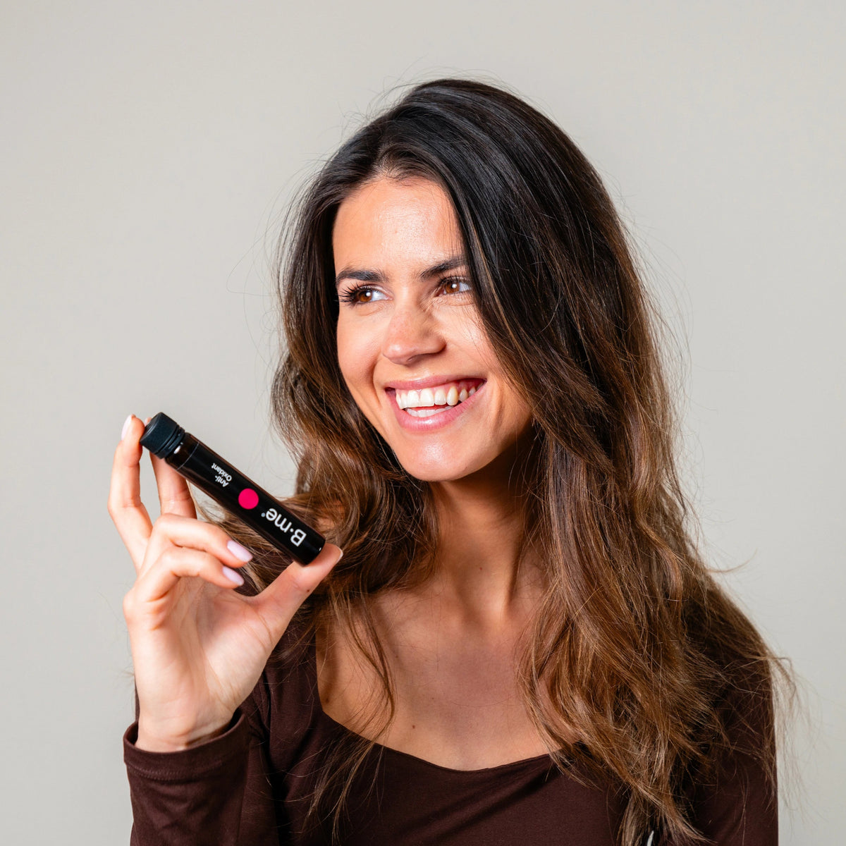 Larissa de Castro smiling while holding B.me antioxidant shot