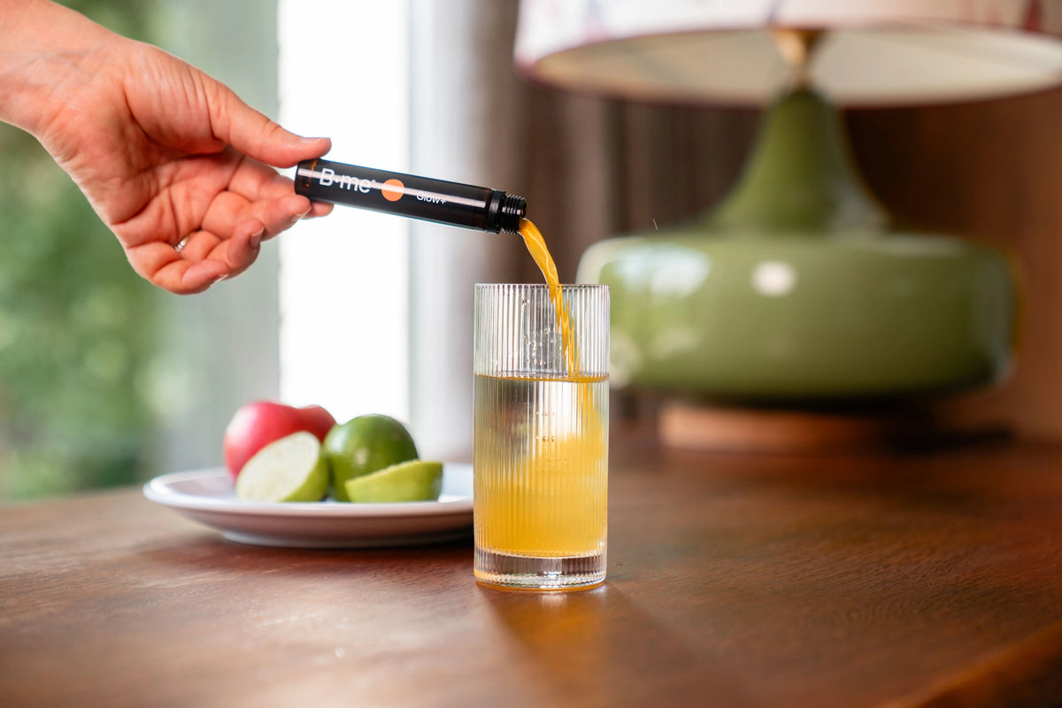 B.me Glow+ shot wordt in een glas water gegoten
