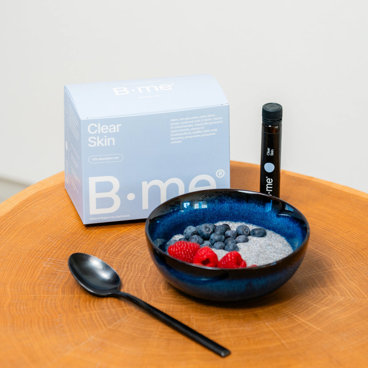 B.me Clear Skin box and supplement shot served with chia pudding, blueberries, and raspberries