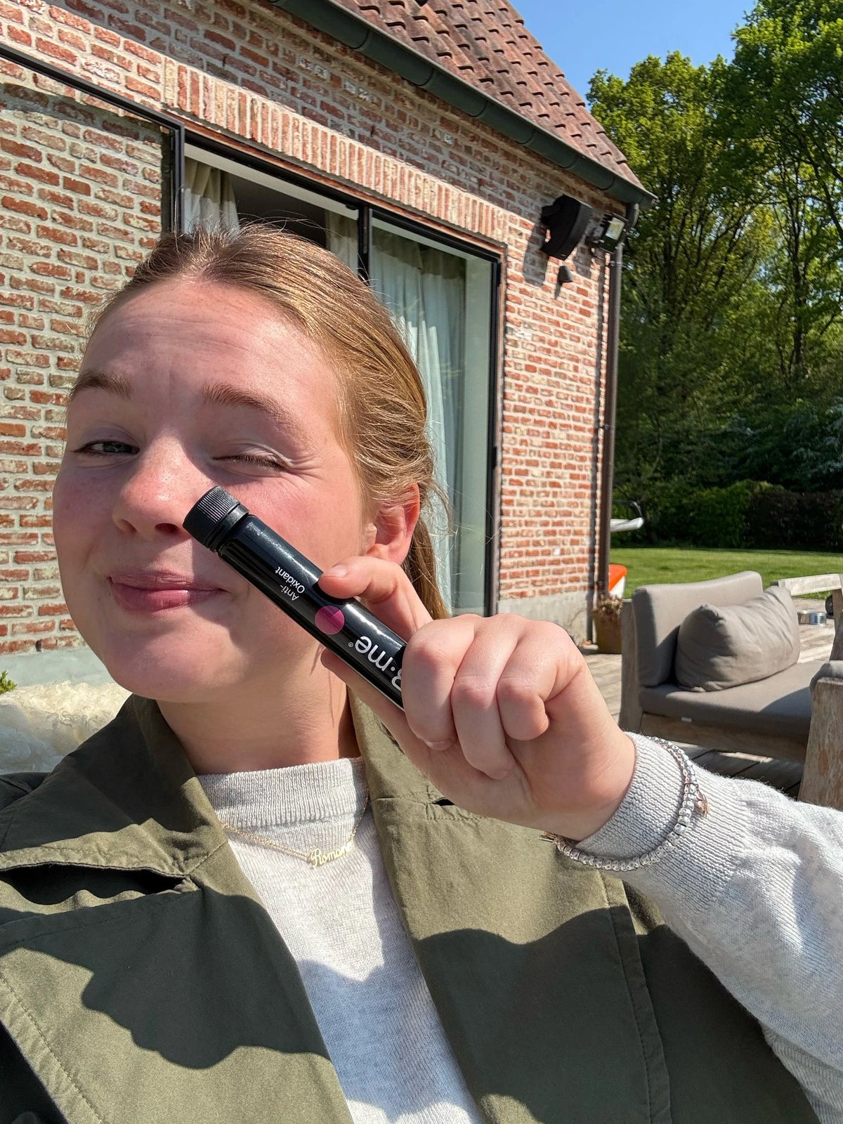 Romane Seynaeve glimlacht in de zon met een B.me Anti-Oxidant shot met SOD in de hand